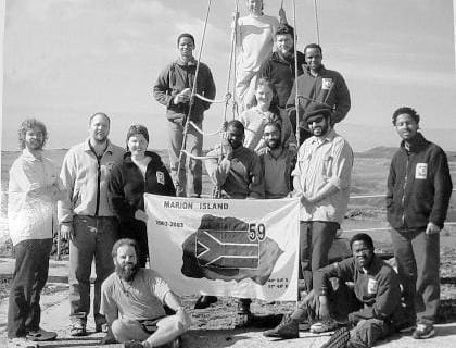 MARION 59 (2002-2003): Back (L-R) Dumile Tshingana (Birder), Michelle du Toit (Birder), Paul Putter (Diesel mechanic), Phineas Phelelo (Meteorologist); Middle: Jacques Deere (Entomologist), Deryck Yelverton (Team leader, radio technician), Elizma Yelverton (Senior Meteorologist), Takalani Maswime (Sealer), Wilna Wilkinson (Entomologist), Alfonzo Mills (Deputy Leader, Medic), Matthew Gasant (Entomologist), Mawethu Nyakatya (Entomologist); Front: Shorty Terblanche (Meteorologist), Lucas Chauke (Sealer).